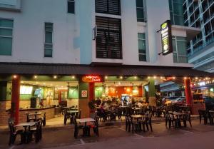 a restaurant with tables and chairs in front of a building at LV Homestay @ Gala Residence in Kuching