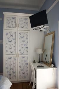 Dormitorio con escritorio con espejo y pared en Tancredi B&B, en Pietermaritzburg
