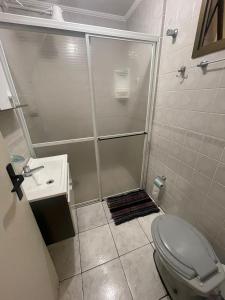 La salle de bains est pourvue d'une douche, de toilettes et d'un lavabo. dans l'établissement Apartamento no Guarujá na praia da Enseada, à Guarujá