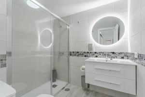 Un baño blanco con lavabo y espejo. en TULUM MEDANO BEACH, en El Médano