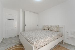 um quarto branco com uma cama e uma porta branca em TULUM MEDANO BEACH em El Médano