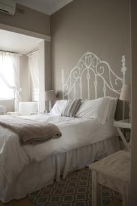 1 dormitorio con 1 cama grande y cabecero blanco en Tancredi B&B, en Pietermaritzburg