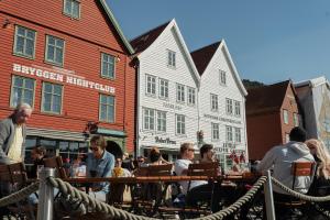 a group of people sitting at tables in front of buildings at Quality Hotel Edvard Grieg in Bergen