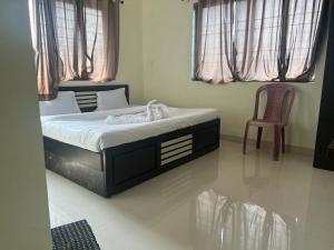 a bedroom with a bed and a chair in it at Blue Bell Homestay in Lonavala