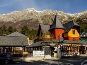 a town with a building with mountains in the background at La Villetta Food & Drink Rooms for Rent - No Reception - in LʼAquila