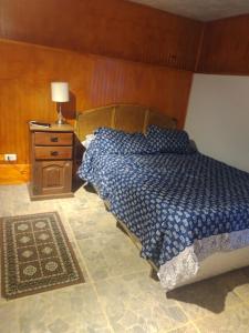1 dormitorio con 1 cama y 1 mesa con lámpara en Linda cabaña interior con piscina y entrada independiente en concon, en Concón