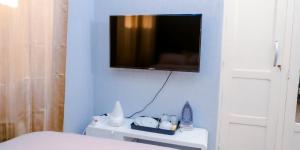 Cette chambre dispose d'une télévision sur un mur bleu. dans l'établissement Studio cosy, à Lomé