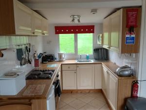 a small kitchen with a stove and a sink at Sea views in Bideford