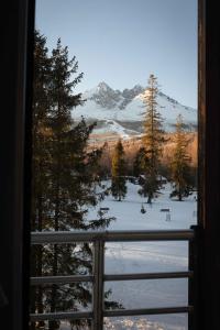 ein Fenster mit Blick auf einen schneebedeckten Berg in der Unterkunft Apartments Tatra Olla - Tatranská Lomnica in Tatranská Lomnica