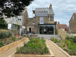 a house with a garden in front of it at Lewknor Lodge: Stunning 5 bed, 4 bathroom house in Ramsgate in Kent