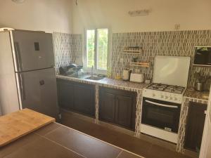 a kitchen with a refrigerator and a stove and a sink at Villa oasis n°5 in Gandigal