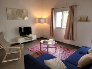 sala de estar con sofá azul y mesa en Villa oasis n°5, en Gandigal
