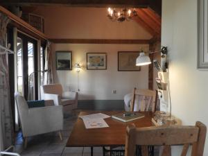 - un salon avec une table et des chaises en bois dans l'établissement Bed&Breakfast 't Eikeltje, à Hollandscheveld