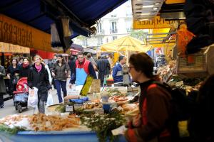a group of people walking through a market with food at Solar Hotel in Paris