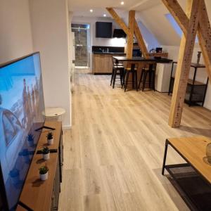 uma sala de estar com pisos em madeira e uma televisão de ecrã grande em Résidence du Lac Blanc appartement chez Jérémy em Orbey