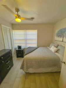 um quarto com uma cama e uma ventoinha de tecto em Cozy, Fam Friendly Home Min from Stkyards em Fort Worth