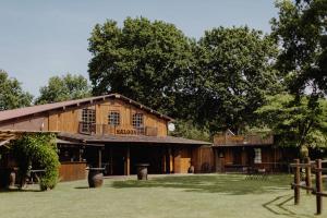 a large wooden barn with a deck on top of it at Le Ranch Amadeus in Saint-Paul-en-Born