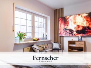 a living room with a fire painting on the wall at Blumenvilla 3 mit Sauna, Garten in Schneverdingen