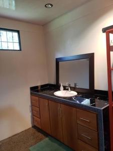 y baño con lavabo y espejo. en Loma Linda Sarapiquí Casa Nueva NEW HOUSE 3bed/2bath, en Tirimbina