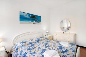 um quarto com uma cama, um espelho e uma cómoda em La casa del pescatore em Alassio