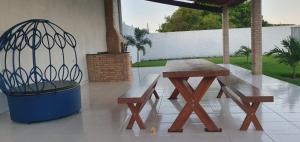 una mesa de picnic y un banco en un patio en TrevizZo Genipabu Natal!, en Natal