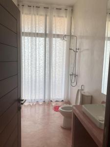 Baño blanco con aseo y lavamanos en Casa di Kasa, en Vipingo