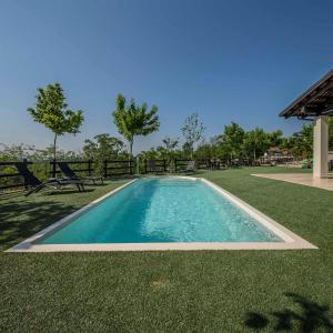 una piscina en medio de un patio de césped en Casa del Rosmarino en Asti