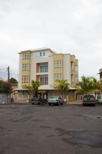 un gran edificio con coches estacionados en un estacionamiento en Le Tribord, en Flic en Flac