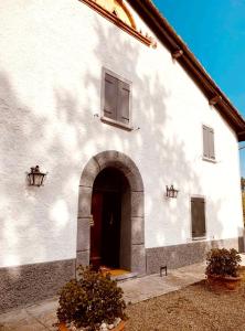 a white building with a door and an archway at Casa Stella Country House in Savigno