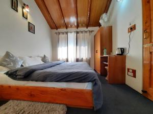 ein Schlafzimmer mit einem großen Bett und einem Fenster in der Unterkunft The Hideout - Hiraeth in Manali