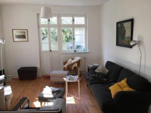 a living room with a black couch and a window at Haus vor dem Schöneberger Tor in Hofgeismar
