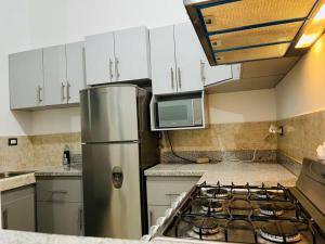 a kitchen with a stainless steel refrigerator and a stove at Moderna casa amueblada en residencial privada in San Miguel