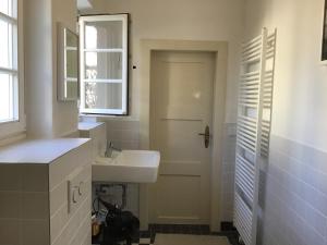 a bathroom with a sink and a white door at Haus vor dem Schöneberger Tor in Hofgeismar +37 photos