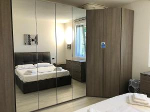 1 dormitorio con cama y armario con espejo en Casa Varisco: Oasis of peace surrounded by nature., en Faggeto Lario 