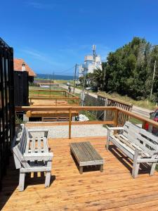 deux bancs et une table sur un pont en bois dans l'établissement Apart Containers, Acantilados, unidad, à Mar del Plata