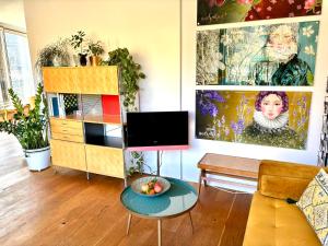 - un salon avec une télévision et une table dans l'établissement SONNEN Loft Bern - Bed & Breakfast, à Berne