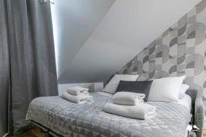 1 dormitorio con 1 cama con toallas en MBA Splendide Appart - Wilson 2 - Mairie de Montreuil en Montreuil