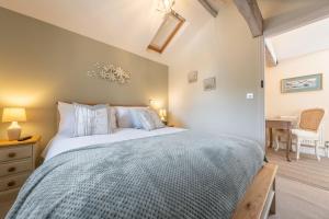 1 dormitorio con 1 cama grande y edredón azul en The Clockhouse en North Lopham