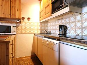 een keuken met een vaatwasser en een fornuis top oven bij Studio Montvalezan-La Rosière, 1 pièce, 6 personnes - FR-1-398-550 in La Rosière