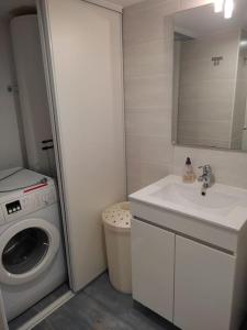 ein Badezimmer mit einer Waschmaschine und einem Waschbecken in der Unterkunft Longère chaleureuse et familiale - 3 chambres in Limerzel