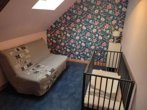 Kleines Zimmer mit einem Bett und Blumentapete in der Unterkunft Longère chaleureuse et familiale - 3 chambres in Limerzel