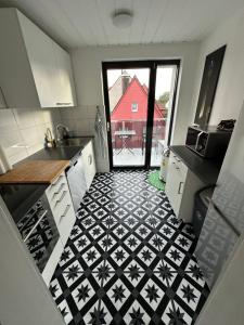 デュッセルドルフにあるFairpartement Düsseldorfの黒と白のタイルフロアのキッチン +4枚の写真