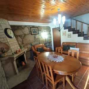 - un salon avec une table en bois et un canapé dans l'établissement Quinta das Amendoeiras, à Mêda