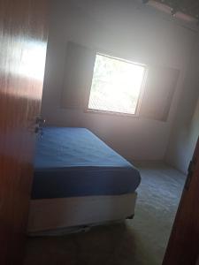 um quarto com uma cama e uma janela em Casa de Andressa em Morro dʼAnta