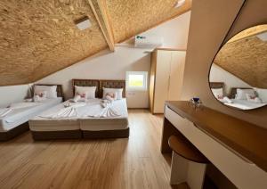 ein großes Schlafzimmer mit 2 Betten und einem Spiegel in der Unterkunft Kompleksi CFN ALBANIA in Pogradec