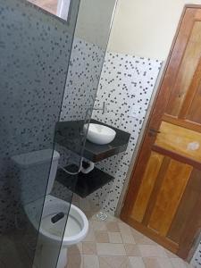 a bathroom with a toilet and a glass shower at Casa de Andressa in Morro dʼAnta