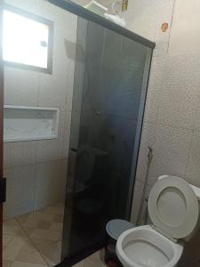 a bathroom with a toilet and a glass shower at Casa de Andressa in Morro dʼAnta