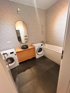 a bathroom with a washing machine a sink and a mirror at Apartament Anca in Sibiu