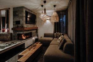 a living room with a couch and a fireplace at Bergchalets Gut Wenghof in Werfenweng