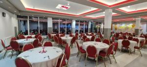 a banquet hall with white tables and red chairs at Kompleksi CFN in Pogradec